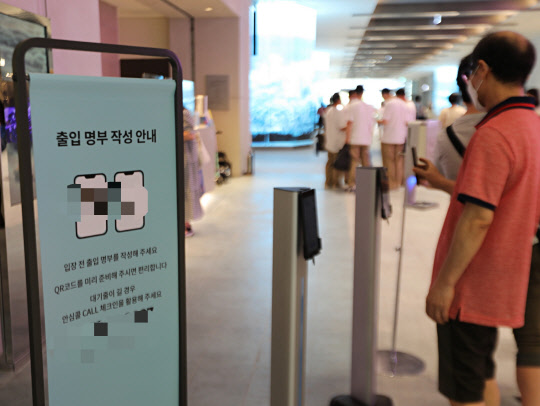 지난 24일 경기 화성시 오산동에 위치한 롯데백화점 동탄점 출입구에서 고객이 QR체크인을 하고 있다. 롯데백화점 제공